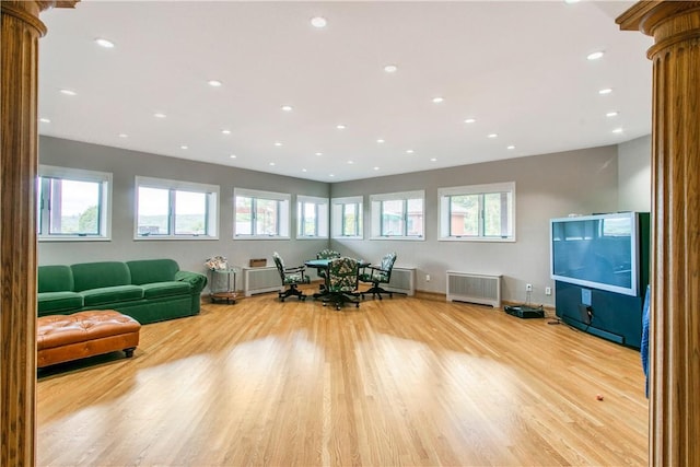 interior space with radiator, light hardwood / wood-style flooring, and decorative columns