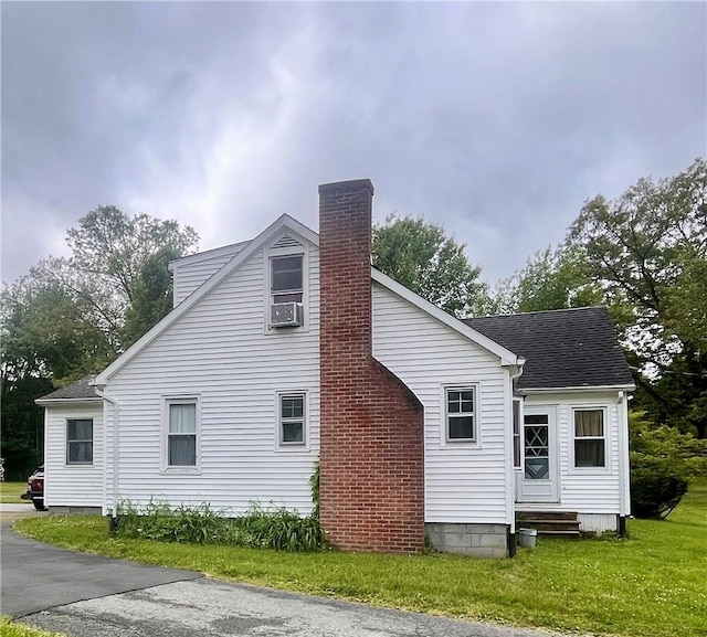 rear view of house with a lawn and cooling unit