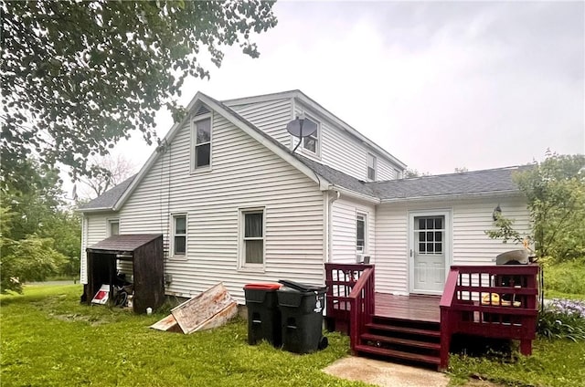 rear view of property with a yard and a deck