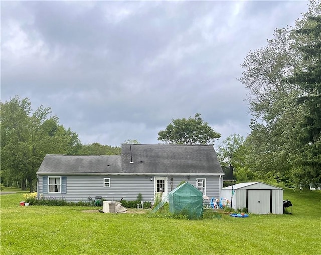 rear view of property featuring a lawn, a storage shed, and central air condition unit