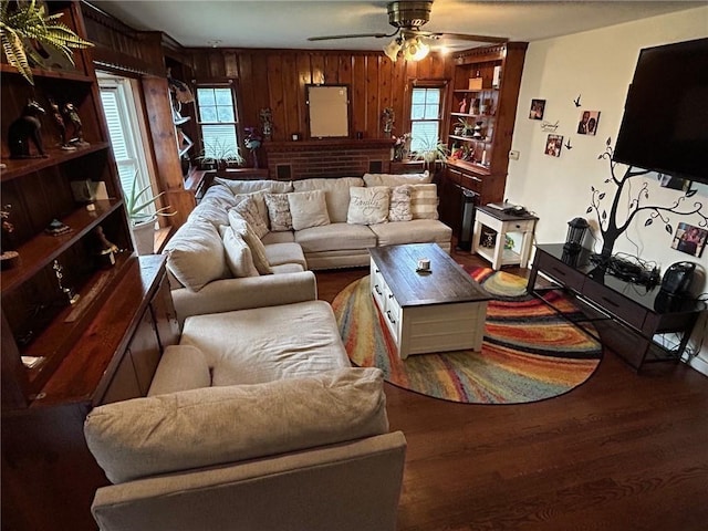 living room with wood walls, ceiling fan, and wood-type flooring