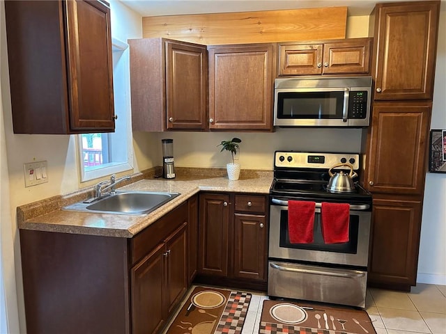 kitchen with light tile patterned flooring, sink, and appliances with stainless steel finishes