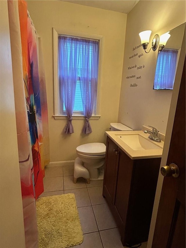 bathroom with tile patterned flooring, vanity, and toilet