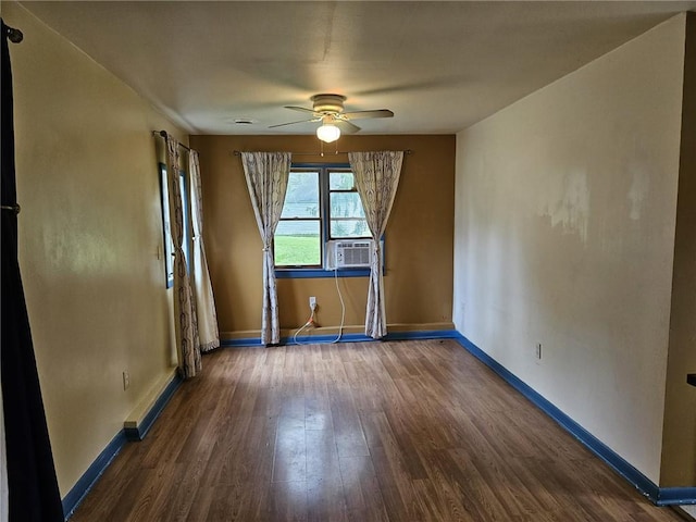 spare room with ceiling fan, cooling unit, and dark wood-type flooring