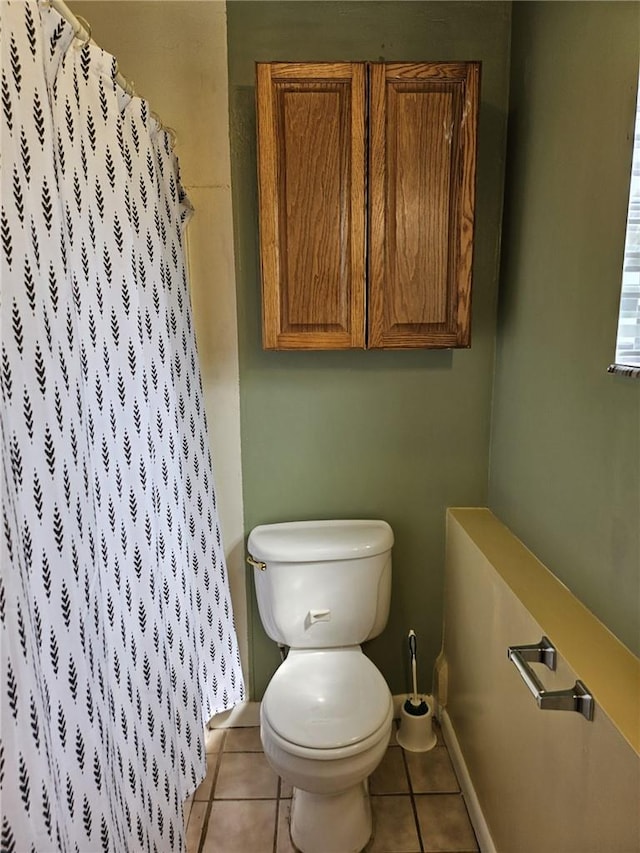 bathroom featuring tile patterned floors, a shower with shower curtain, and toilet