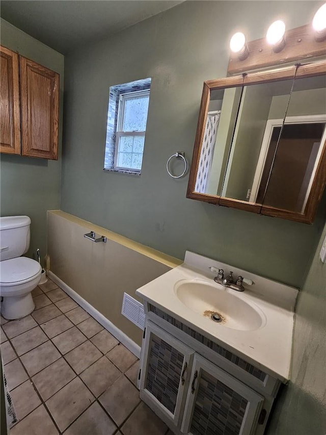 bathroom with tile patterned flooring, vanity, and toilet