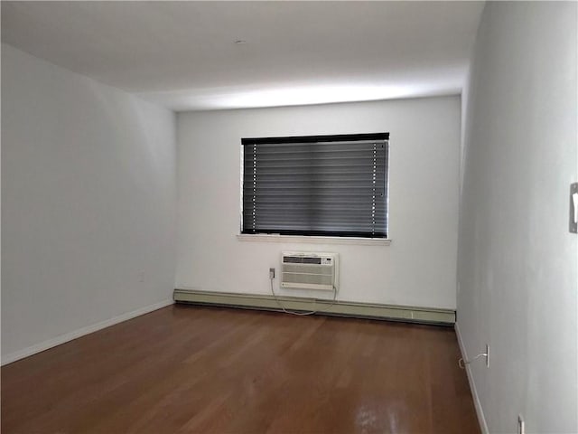 empty room featuring wood-type flooring, a baseboard radiator, and an AC wall unit