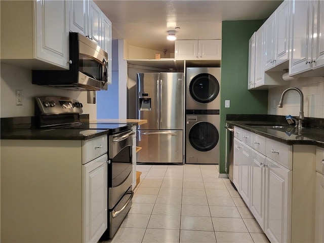 kitchen featuring white cabinets, stacked washing maching and dryer, and appliances with stainless steel finishes