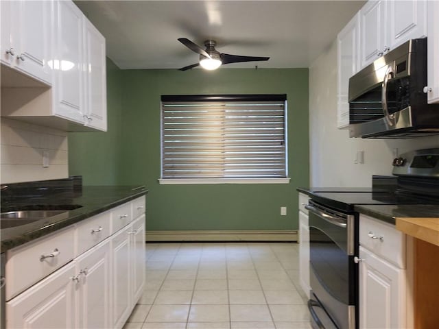 kitchen featuring appliances with stainless steel finishes, ceiling fan, a baseboard heating unit, white cabinets, and light tile patterned flooring