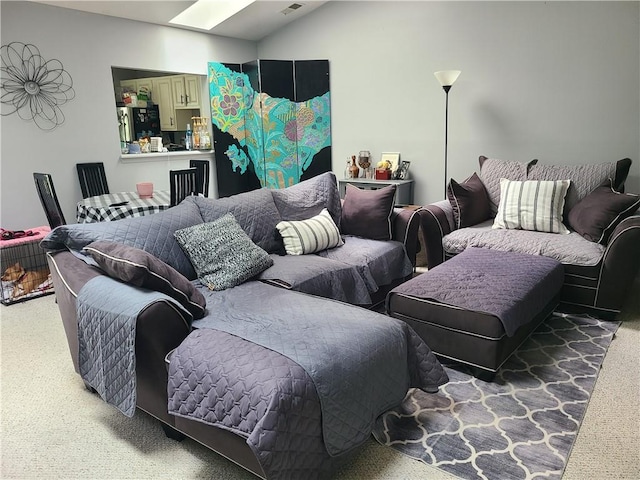 carpeted living room featuring a skylight