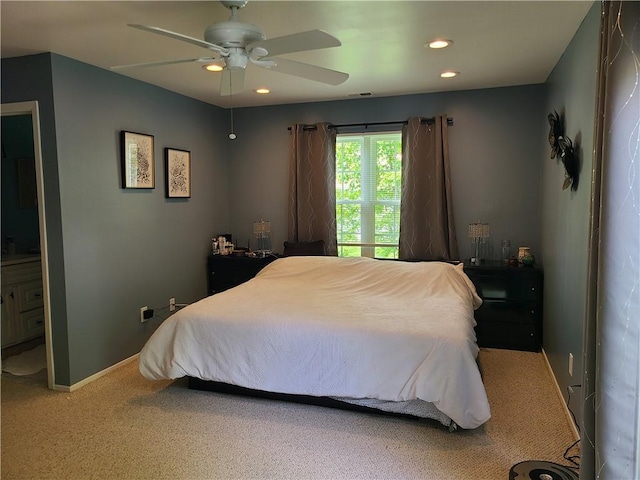 bedroom with ceiling fan, carpet floors, and connected bathroom