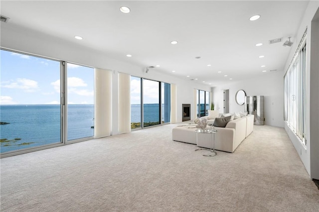 carpeted living room with a water view