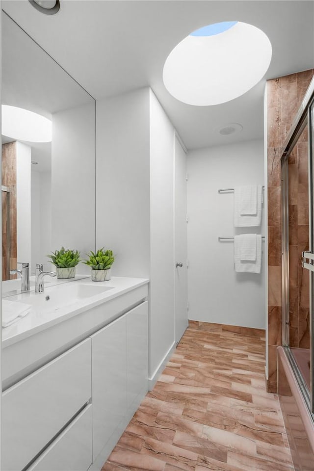 bathroom featuring hardwood / wood-style floors, vanity, and enclosed tub / shower combo