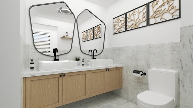 bathroom with vanity, toilet, and tile walls