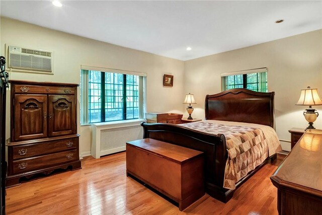 915 Wynnewood Rd Unit G2, Pelham, NY 10803 - bedroom featuring radiator heating unit, an AC wall unit, multiple windows, light wood-style floors, and recessed lighting