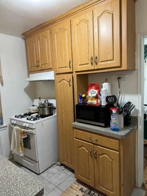 kitchen with light tile patterned flooring and white range with gas cooktop