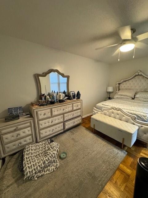 bedroom with ceiling fan and dark parquet floors