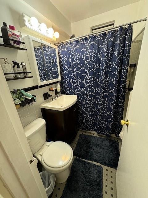 bathroom featuring walk in shower, vanity, toilet, and tile walls