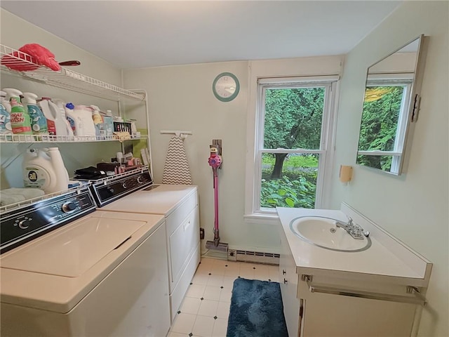 clothes washing area with a wealth of natural light, independent washer and dryer, baseboard heating, and sink