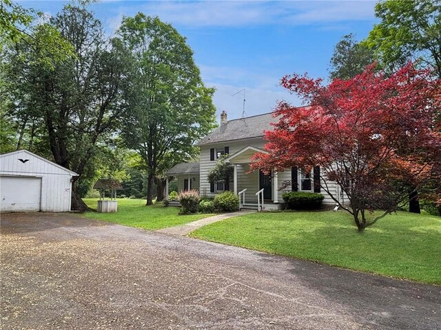 view of front facade with a garage, a front lawn, and an outdoor structure