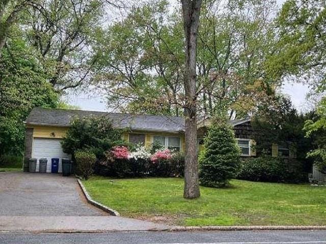 ranch-style home with central AC, a front lawn, and a garage