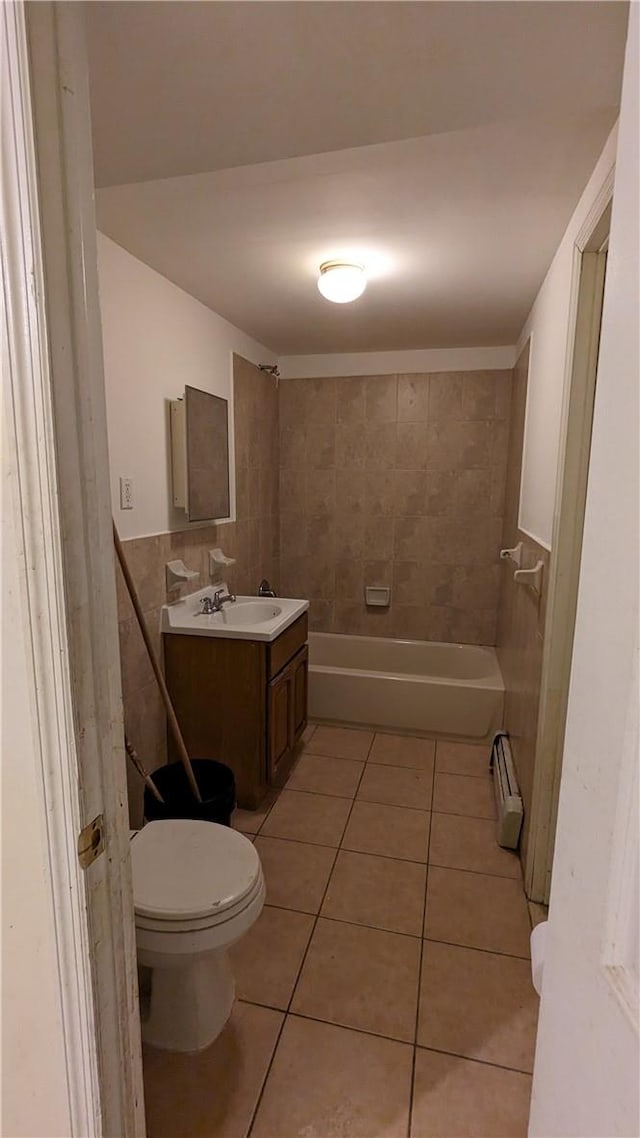 bathroom with vanity, a baseboard heating unit, tile patterned floors, toilet, and tile walls