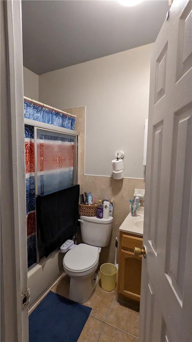 full bathroom with shower / tub combo, vanity, tile walls, tile patterned flooring, and toilet