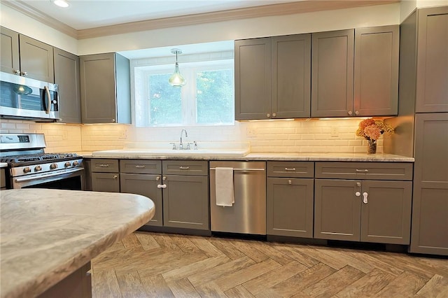 kitchen featuring gray cabinetry, light parquet floors, crown molding, light stone countertops, and appliances with stainless steel finishes