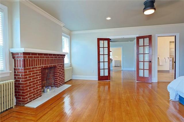 unfurnished living room with radiator, crown molding, french doors, and hardwood / wood-style flooring