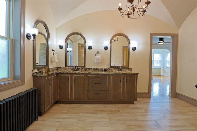 bathroom with radiator heating unit, vanity, and lofted ceiling