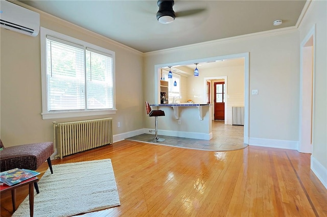 interior space featuring radiator, ceiling fan, hardwood / wood-style floors, and a wall mounted air conditioner