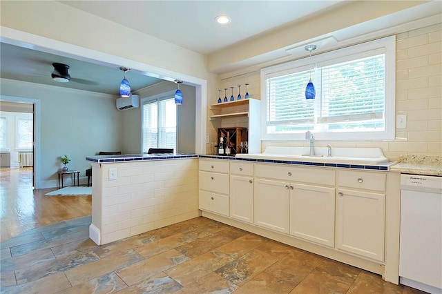 kitchen with dishwasher, plenty of natural light, decorative light fixtures, and radiator heating unit