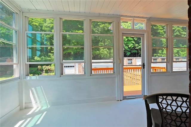 unfurnished sunroom featuring a healthy amount of sunlight and wood ceiling