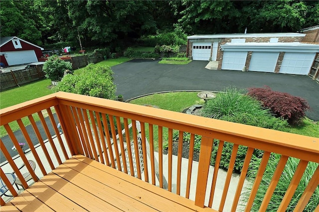 wooden deck featuring a lawn and an outdoor structure