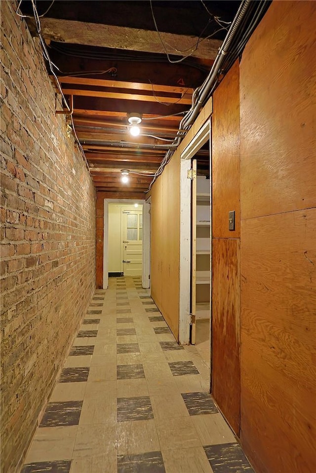 basement featuring wood walls and brick wall