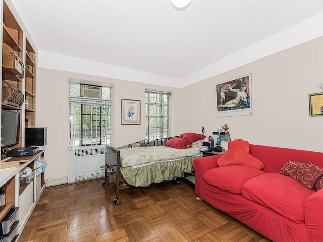 bedroom featuring radiator heating unit and dark parquet floors