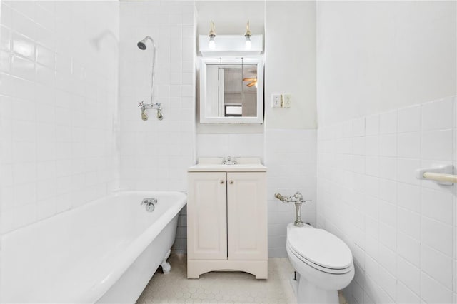 bathroom with vanity, tile patterned flooring, toilet, tile walls, and a tub