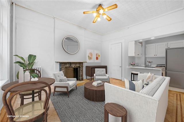 living room with light hardwood / wood-style flooring and ceiling fan