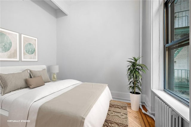 bedroom featuring hardwood / wood-style flooring and radiator