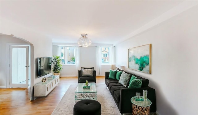 living room featuring a chandelier and light wood-type flooring