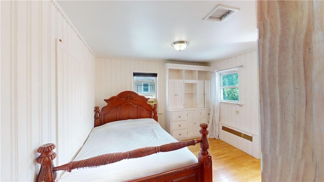 bedroom featuring light wood-type flooring and radiator