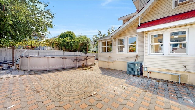 view of patio with a fenced in pool and central AC