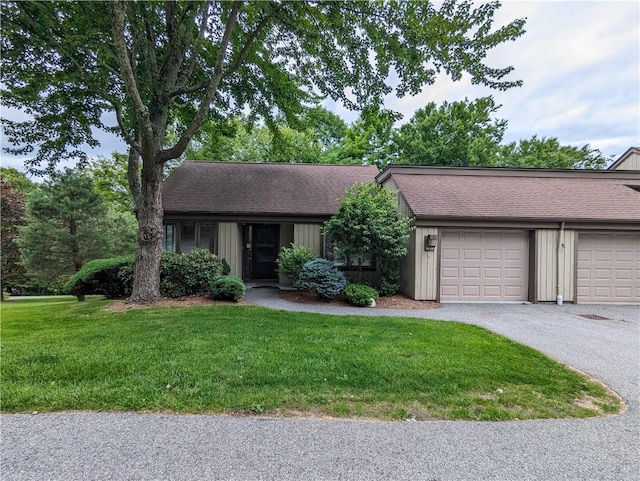 single story home with a garage and a front lawn