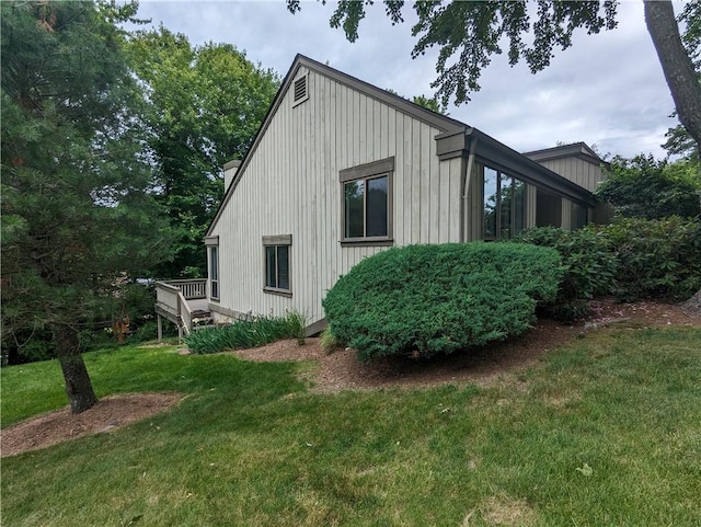 view of side of property with a deck and a yard