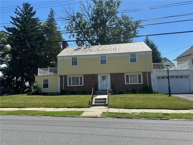 view of front facade with a front yard and a balcony