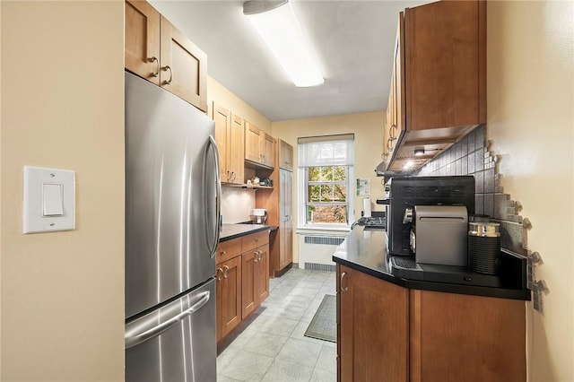 kitchen with stainless steel fridge and radiator heating unit