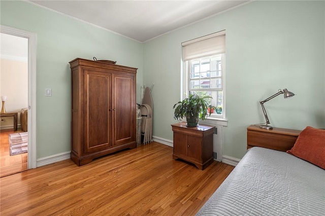 bedroom featuring light hardwood / wood-style flooring and crown molding