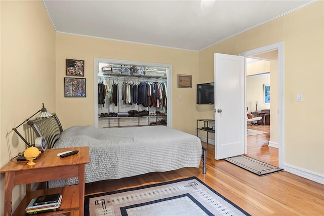 bedroom featuring hardwood / wood-style floors, a closet, and crown molding