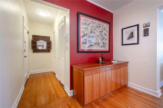 hall featuring crown molding and light hardwood / wood-style floors