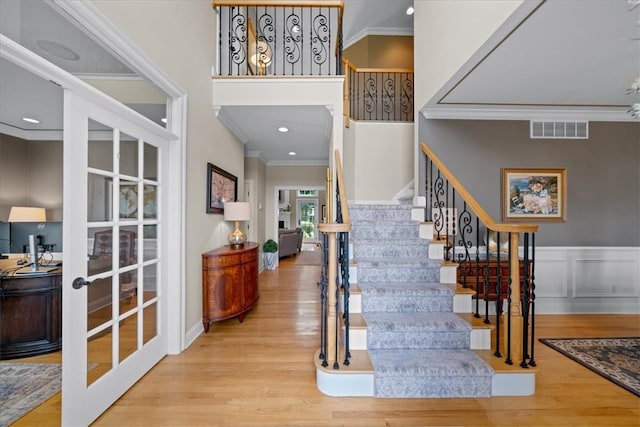 staircase featuring hardwood / wood-style flooring and ornamental molding